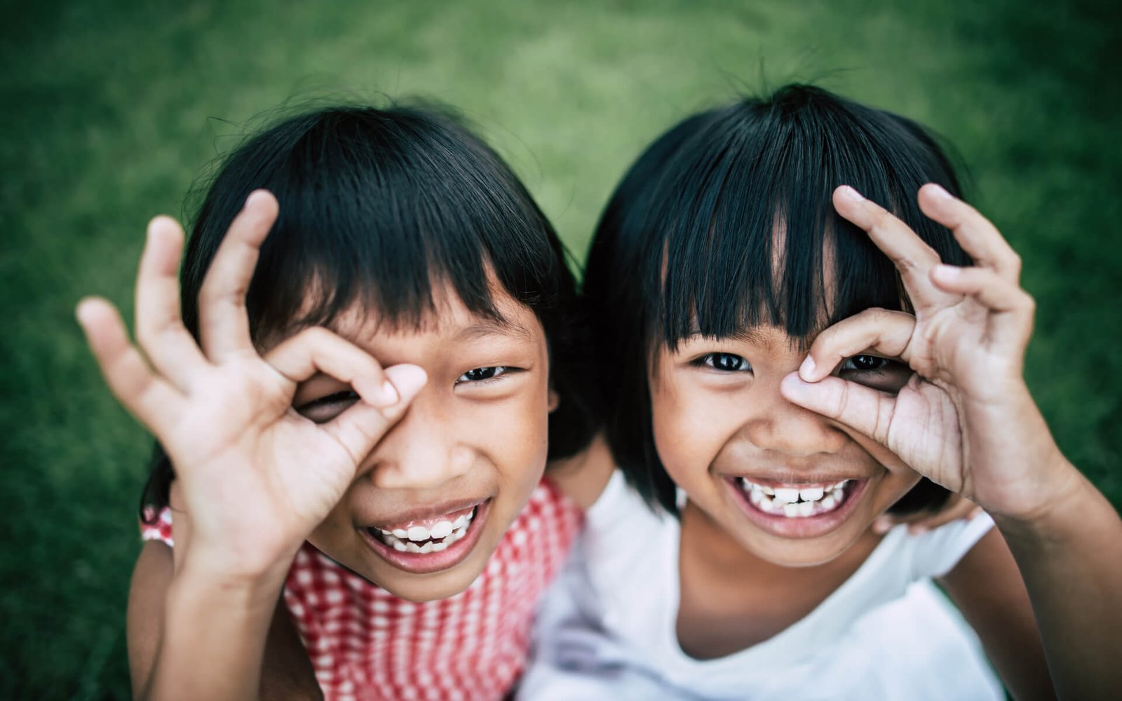 Two little girls playing in a park, representing the community our mission serves